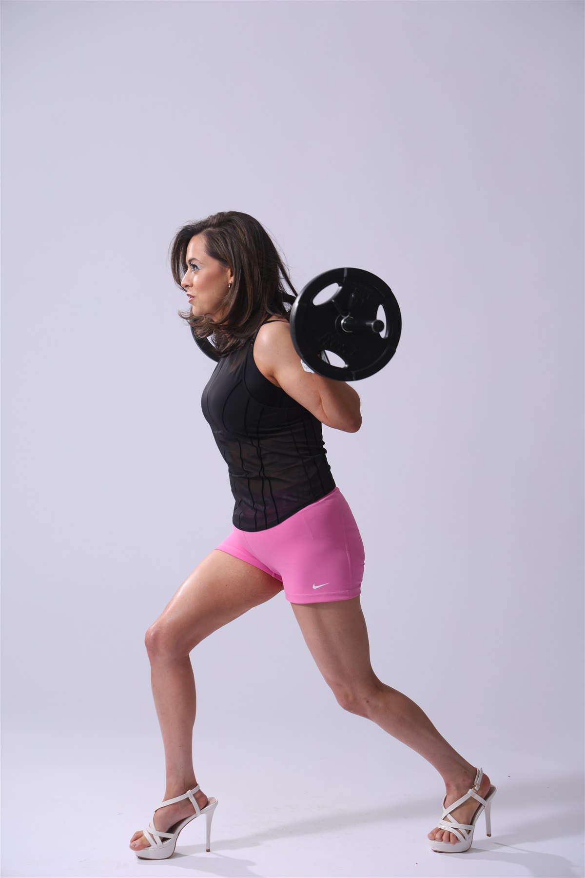 Michelle Lush with a barbell in a pale studio